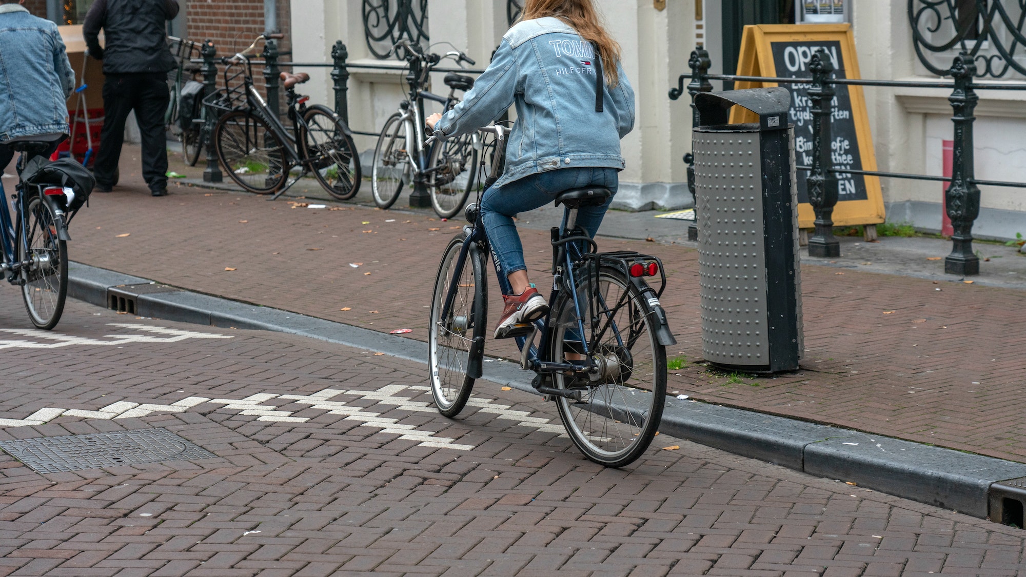 Girl riding bicycle in Amsterdam, urban street, scene, city, rider, city living, Amsterdam.