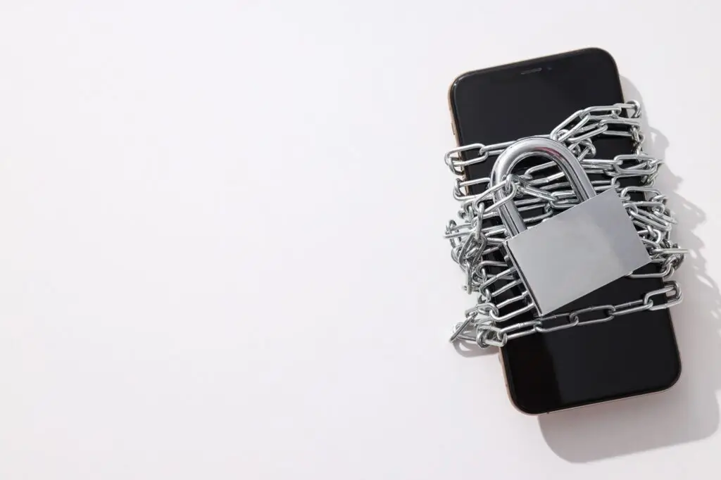 The smartphone is encased in a chain with a lock